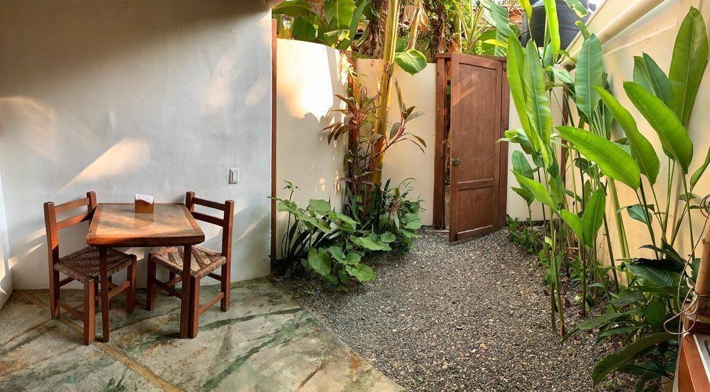 Galería Suites San Pancho: small patio with a table for two among tropical plants